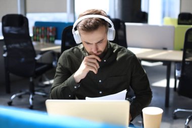 Başarılı girişimci dikkatli ve yoğun bakışla belgeleri inceliyor.