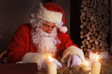 Mutlu Noel Baba 'nın portresi Noel ağacının yanındaki odasında oturuyor ve Noel mektuplarına cevap veriyor.