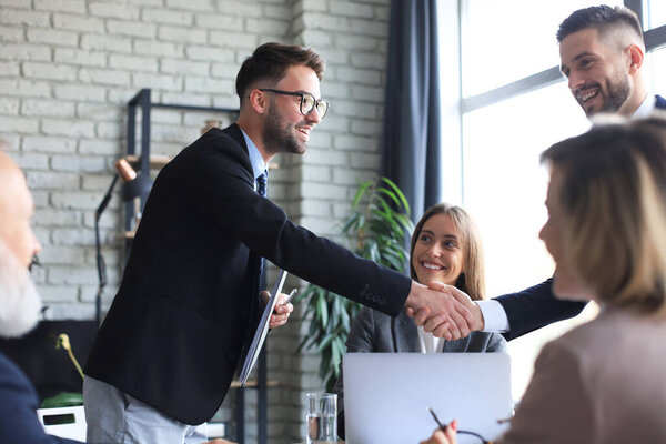 Деловые люди пожимают друг другу руки, заканчивают встречу