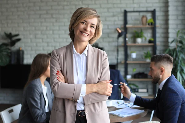 Business woman with her staff, people group in background at modern bright office indoors. — Stock Photo, Image