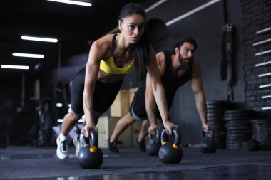 Sportif Hintli erkek ve kadın spor salonunda şınav çekiyor.