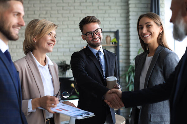 Деловые люди пожимают друг другу руки, заканчивают встречу