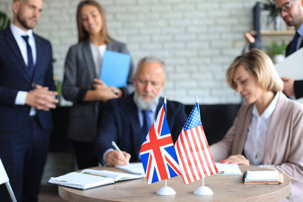 Two business partners signing a document. The United States of America and Great Britian