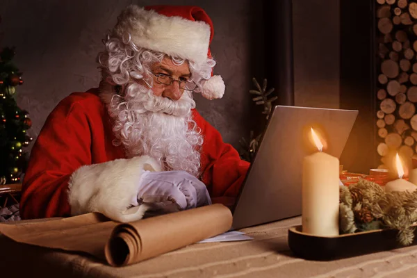 Papai Noel Usando Computador Portátil Sentado Quarto Acolhedor Perto Lareira — Fotografia de Stock