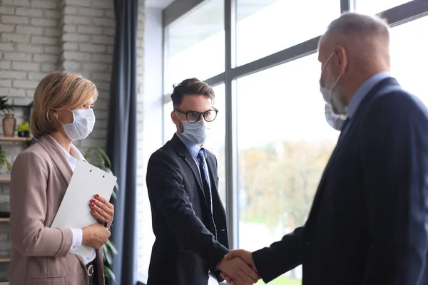 Les Hommes Affaires Masques Médicaux Serrent Main Finissant Une Réunion — Photo