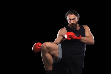 Kickboksçu adam siyah arka plana karşı savaşıyor. Spor konsepti