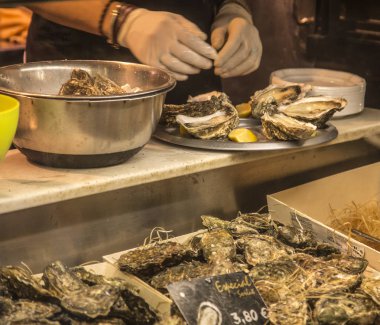 Kadın bir pazarda istiridye açma