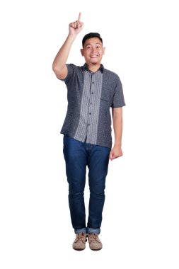 Parmak hareketi işaret mavi kot pantolon ve batik tişört giyen genç Asyalı adam. Beyaz izole. Tam vücut portre