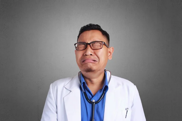 A Young Asian doctor with eyeglass. Crying or sad concept