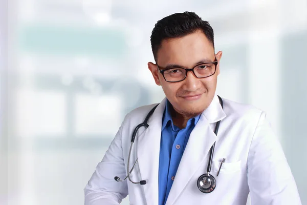 眼鏡で若いアジア医師の笑顔 自信を持ってポーズとカメラ目線 — ストック写真