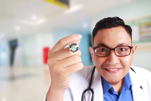 Joven Médico Asiático Con Anteojos Sostiene Una Jeringa Sonriendo Aislado — Foto de Stock