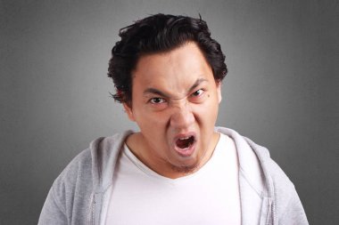 Çığlık, kameraya bakarak kızgın ve bağırıyordu, ceket Genç Asyalı adam portresi