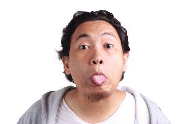 Giyen genç Asyalı erkek ceket komik surat, dilini dışarı yapıştırma, üzerinde beyaz arka plan, insan yüz ifadeleri, göl kenarında ile alay duygu, tutum, beden dili, Reactio