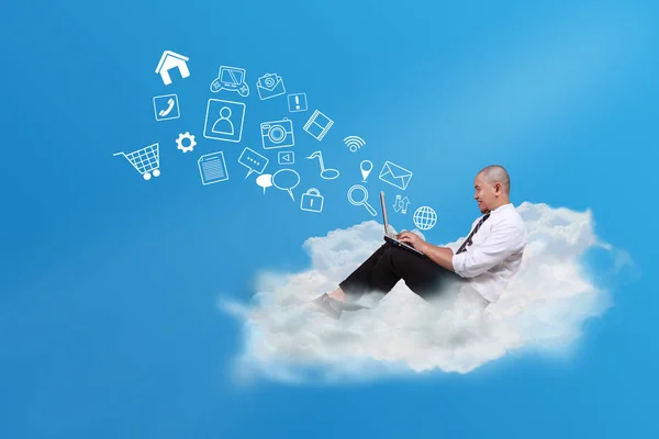 在蓝天上坐在白云上的秃头亚裔商人在笔记本电脑上打字 云计算网络概念 — 图库照片