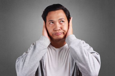 Genç Asyalı adam kaplı onun kulak, Yoksay basınç