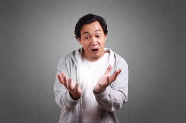 Şok Genç Asyalı adam giyen ceket, gülen ve gülerek onun palm her ikisi de açık gösterilen heyecan