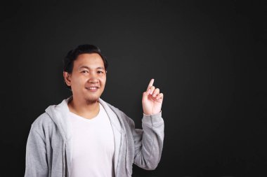 Jest atanması beyaz gömlek ve bir şey yazı tahtası üzerinde gösterilen gri ceket giyen genç Asyalı adam. Uzay kopyalayın. Vücut portre kadar kapatın