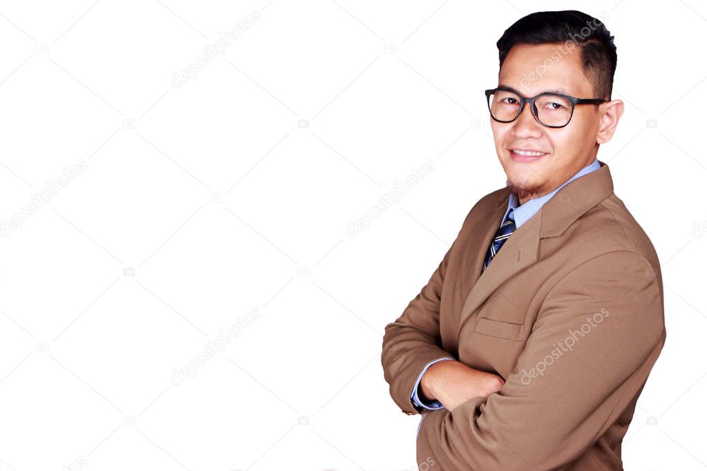 Young Asian businessman wearing suit and glasses smiling at the camera, crossed arm. Isolated on white. Close up body portrait