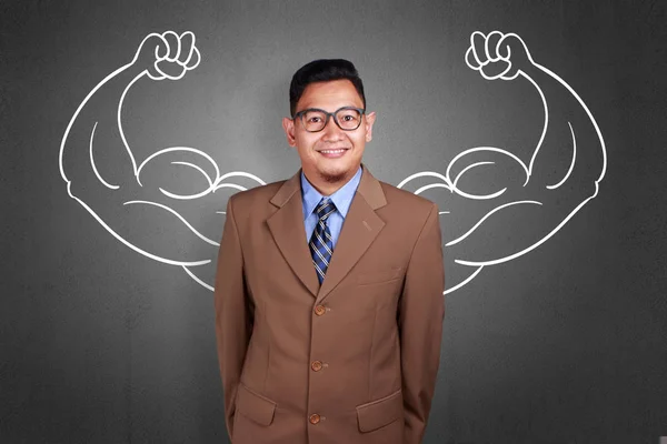 Business power concept. Young funny Asian businessman  smiling with strong powerful arms drawn behind. Inner power authority