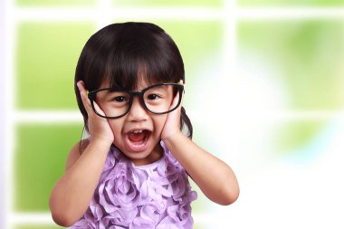 Genç Asyalı sevimli küçük kız neşeyle, giyim gözlük gülümseyen