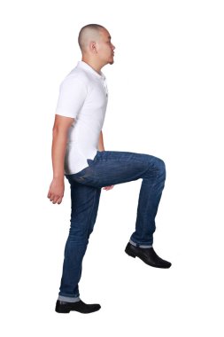 Tam vücut beyaz polo gömlek ve adım kadar yürüyüş kot giyen kel bir Asya adam portresi, yan görünüm üzerinde beyaz izole.