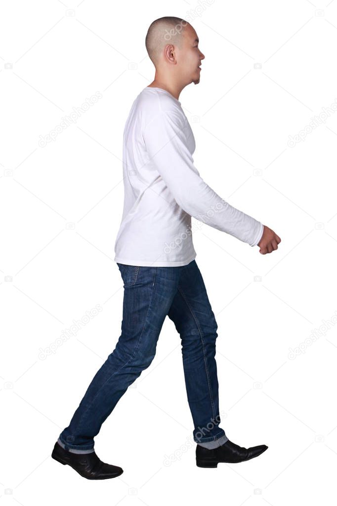 Full portrait of a bald Asian man wearing long sleeved white shirt and jeans walking, side view isolated on white