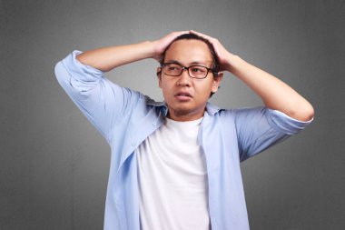 Beyaz ve mavi gömlek giymiş genç Asyalı adam yorgun, jest hayal kırıklığına. Saçları çok dokunaklı. Vücut portait kadar kapatın