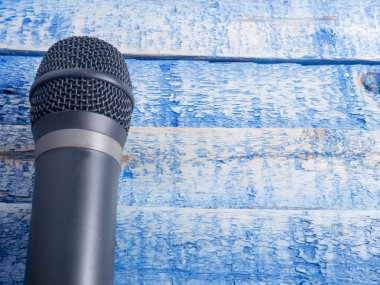 Mikrofon kopya alanı ile. Mic mavi ahşap zemin üzerinde. Şarkı karaoke şarkı kavramı