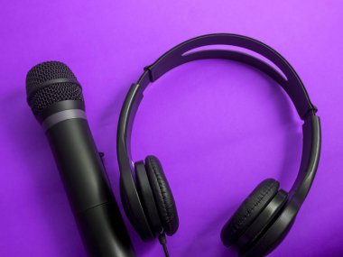 Kulaklık ve mikrofon. Kulaklık mor zemin üzerine. Dinleme müzik ses ve şarkı karaoke şarkı kavramı