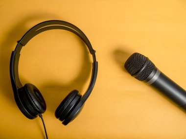 Kulaklık ve mikrofon. Kulaklık turuncu zemin üzerine. Dinleme müzik ses ve şarkı karaoke şarkı kavramı