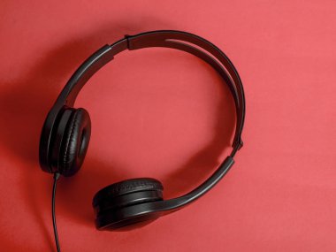 Kulaklık. Kulaklık kırmızı zemin üzerine. Müzik ses konsepti