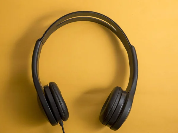 Headphone. Earphones on orange background. Music sound concept