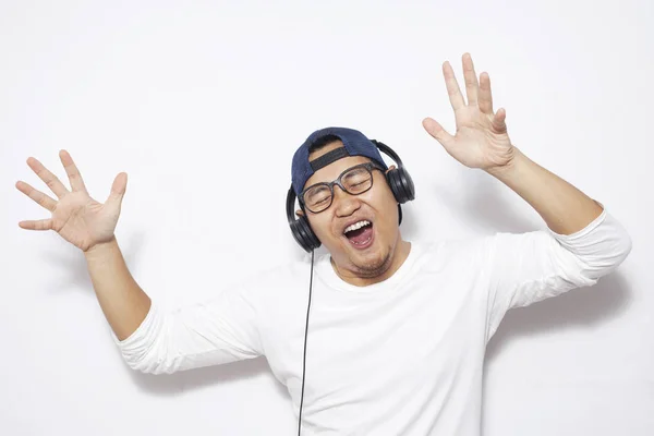 Фото Счастливого Молодого Азиата Шляпе Очках Танцующего Музыку Наушниках Против — стоковое фото