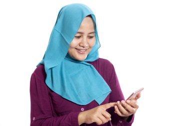 Mutlu Asyalı Müslüman kadının portresi. Mesajı okurken gülümsüyor. Akıllı telefonundan iyi haberler geliyor.
