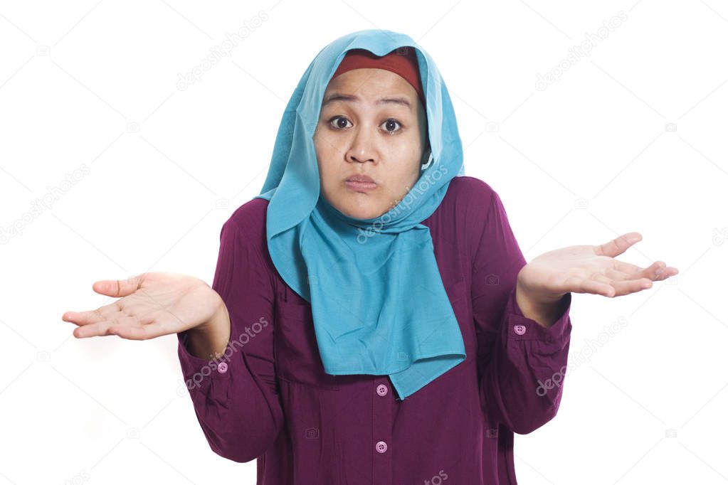 Portrait of Asian muslim woman shrugging shoulder, denial or I don't know gesture isolated on white