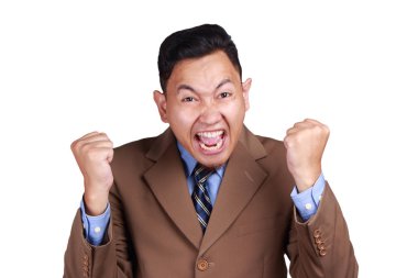 Genç Asyalı adam mutlu ifade gösterilen, zafer jest kutlama takım elbise giymiş. Vücut portre üzerinde beyaz izole kapatmak