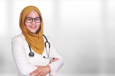 Mutlu gülümseyen Asya Müslüman kadın giyen hijab ve Süiti portresi. Güven kadın doktor ile çapraz kollar, sağlık ve tıp kavramı