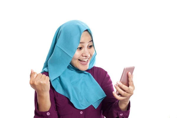 若いアジアのイスラム教徒の女性の肖像画は 白で隔離 彼女の携帯電話 幸せな驚きの表情で良いニュースを取得します — ストック写真