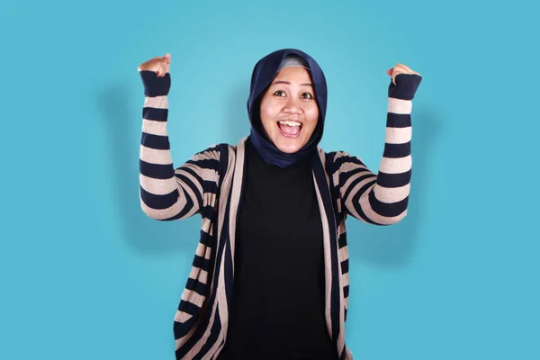 成功的肖像美丽的穆斯林妇女戴头巾笑与胜利的姿态在蓝色背景 — 图库照片
