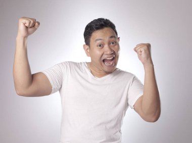 Komik Genç Asyalı erkek gösterir kazanan jest, portresi açık ağız ile şaşırttı şok. Eller yukarıda kaldırdı