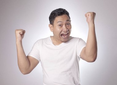 Komik Genç Asyalı erkek gösterir kazanan jest, portresi açık ağız ile şaşırttı şok. Eller yukarıda kaldırdı