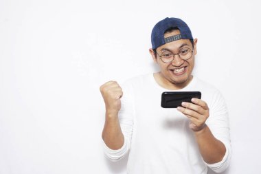 Fotoğraf resim portre sevimli yakışıklı genç Asyalı adamın komik surat tablet akıllı telefonda oyunlar oynamak ile