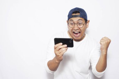 Fotoğraf resim portre sevimli yakışıklı genç Asyalı adamın komik surat tablet akıllı telefonda oyunlar oynamak ile