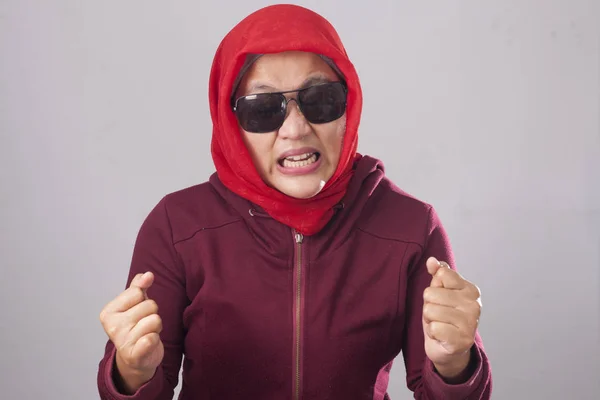愤怒的穆斯林妇女穿着红色西装和头巾的黑色太阳镜的肖像显示疯狂的疯狂手势 — 图库照片