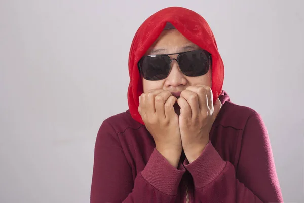 赤いスーツとヒジャーブに黒のサングラスをかけてアジアのイスラム教徒の女性の肖像画を見て心配して何か悪い 爪を噛むを恐れて — ストック写真