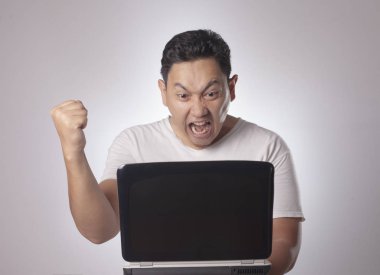 Küçük Asya giyiyor rahat beyaz gömlek laptop, kızgın jest arıyorum dostum. Vücut portre kadar kapatın