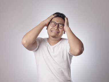 Komik Asyalı adamın resmi. Gözlerini kapat, depresyon, hayal kırıklığı, umutsuz surat ifadesi.