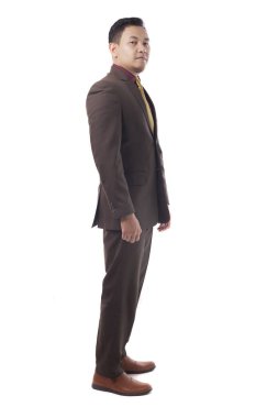 Takım elbiseli genç bir işadamı dikiz aynasından bakıyor. Beyazda izole edilmiş. Tüm vücut portresi