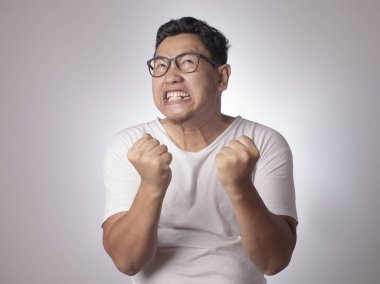 Küçük Asya öfke yüzünden giyen beyaz gömlek bağıran adam. Arka plan gri. Baş ve omuzlar kapatın