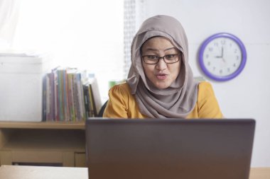 Ofiste, dizüstü bilgisayarda çalışma Asya Müslüman işkadını portresi şok sürpriz mutlu hayret ifadesi